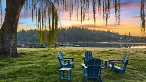 A grassy area with three blue Adirondack chairs and a large tree. - 3B2B Upper Unit w/ Oceanfront & Rainier Views (Bremerton)