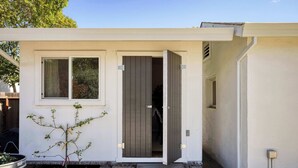A modern house with a white exterior, a small front yard, and a door leading to the interior. - Stylish Retreat. Grand Private Yard. Fire Pit. A/C (Napa)