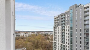 A high-rise building with multiple balconies and large windows, surrounded by other residential buildings and trees. - Horizon 133 - SeaView by GrandApartments (Gdansk)