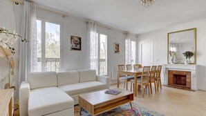 A modern living room with a sofa, coffee table, dining table, and chairs. - BM-Style Parisien a Republique (Paris)
