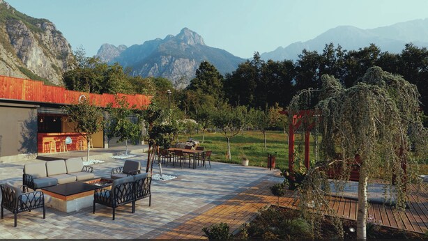 An outdoor patio with seating, a barbecue area, and a view of mountains. - Plis Bujtina (Margegaj)