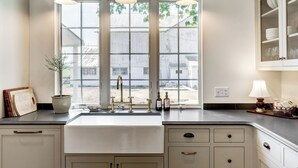 Una cocina con un ventanal amplio, un lavamanos y armarios.
