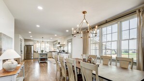 Una cocina amplia con comedor, ventanas grandes y electrodomésticos modernos.