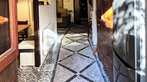Una cocina con un refrigerador moderno de acero inoxidable, piso de baldosas con diseño y techo de madera.