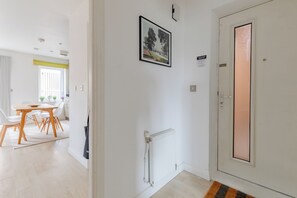 A hallway with a white door, a radiator, and a framed picture on the wall.