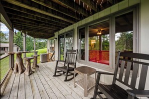 A wooden deck with rocking chairs and a table, overlooking a green landscape. - Mountain View, 3 minutes to downtown Banner Elk, easy access and ample parking! (Beech Mountain)