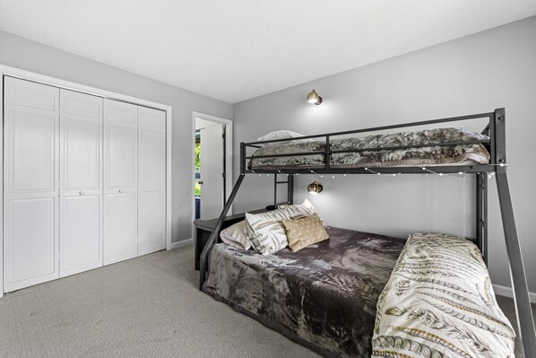 A bunk bed with a headboard, a white closet, and a door leading to a balcony. - Mountain View, 3 minutes to downtown Banner Elk, easy access and ample parking! (Beech Mountain)
