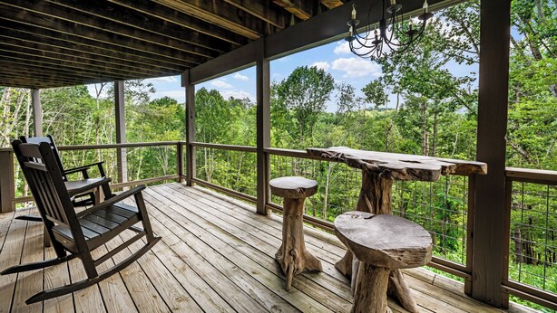A wooden deck with a rocking chair and two stools, overlooking a forested area. - Mountain View, 3 minutes to downtown Banner Elk, easy access and ample parking!  (Beech Mountain)