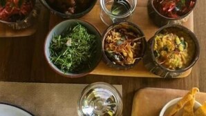 Ein Tisch mit verschiedenen Speisen, darunter Reis, Salate und eine Suppenschüssel.