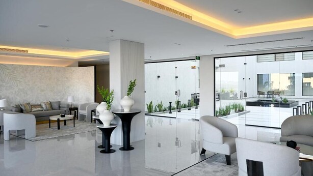 Un moderno vestíbulo de hotel con un diseño espacioso, una columna central y vistas al exterior.