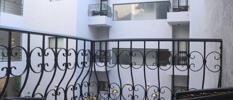 A balcony with wrought iron railings and wicker furniture.