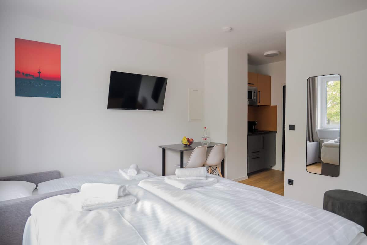 Una habitación de hotel moderna con cama, escritorio y televisión.