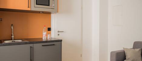 Cocina compacta con microondas, un lavabo y una encimera.
