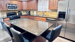 A kitchen with granite countertops, stainless steel appliances, and wooden cabinets. - Entire Spacious 4 BR Home for Teams (Port Arthur)