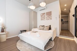 A modern bedroom with a bed, bedside tables, and a small bedside table with a plant.