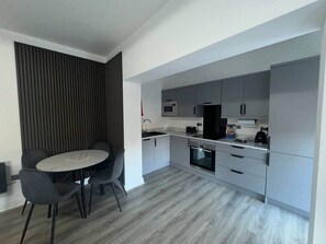 A modern kitchen with grey cabinets, a microwave, and a built-in oven. - Apt 4, 38 Everton Road (Liverpool)