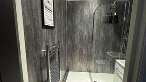 Un bagno moderno con doccia, lavabo e WC.