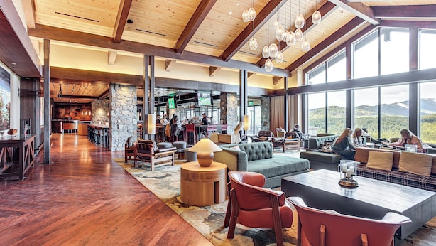 A spacious lobby with a wooden floor, a stone wall, and a large window offering a mountain view. There are several seating areas with sofas and chairs. - Stay & Play: Suncadia Resort Condo in Cle Elum (Cle Elum)