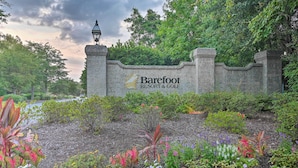Un mur de pierres sur lequel est inscrit « Barefoot Resort & Golf », ainsi qu’un lampadaire.