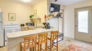 A compact kitchen with a central island, a microwave, a stove, and a ceiling fan. - Dock & Fire Pit: Scenic Studio on Suwannee River! (Chiefland)