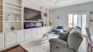 A modern living room with a flat-screen TV, white cabinets, a glass coffee table, and a grey sofa. - 5 Mi to Rutgers University: New Jersey Guest Suite (South River)