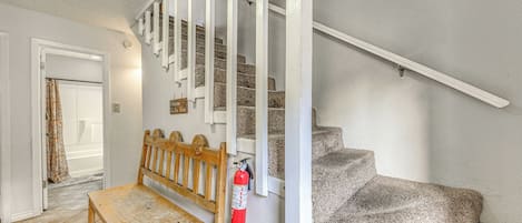 A staircase with white railings and a wooden bench at the bottom.