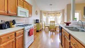 A kitchen with wooden cabinets, a white stove, and a sink. - 2 Mi to Heritage Park: Pet-friendly Mcdonough Home (McDonough)