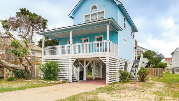 A two-story house with a balcony and a covered porch. - Steps to Beach: Centrally Located OBX Home! (Kill Devil Hills)