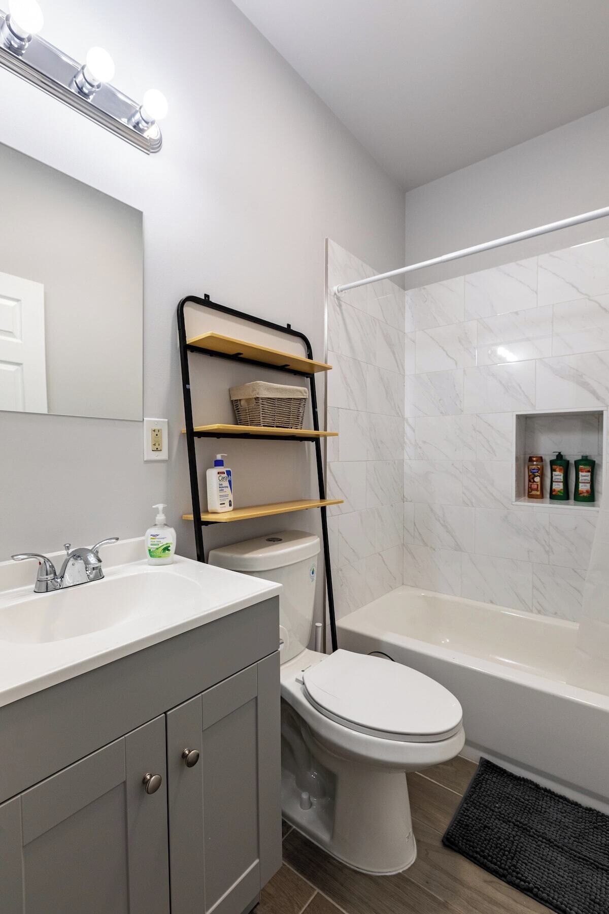Un bany modern amb un lavabo, vàter i dutxera.