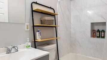 Un bany modern amb un lavabo, vàter i dutxera.