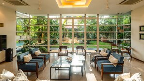 Un amplio salón con ventanas grandes, asientos cómodos y una mesa de centro.