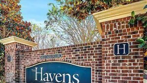 A brick wall with a sign that reads "The Havens" and a smaller sign with the letter "H". - Havens 1311 Beautiful Condo! (North Myrtle Beach)