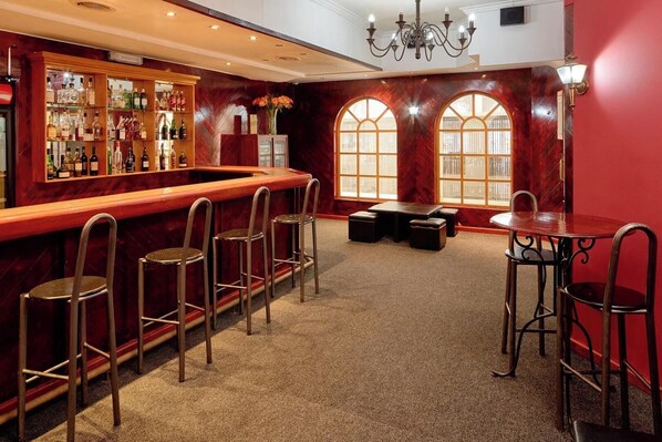 A bar area with a marble counter, stools, and a table with chairs. - Penthouse 711 at La Montagne by First Private Stays (Ballito)