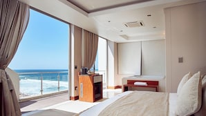 A hotel room with a large bed, a desk, and a view of the ocean. - Penthouse 712 at La Montagne by First Private Stays (Ballito)