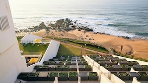 A rooftop terrace with multiple planters and a view of a beach with rocks and waves. - Penthouse 712 at La Montagne by First Private Stays (Ballito)
