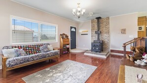 A living room with a sofa, a rug, a fireplace, and a staircase. - Country Charmer (Sevierville)