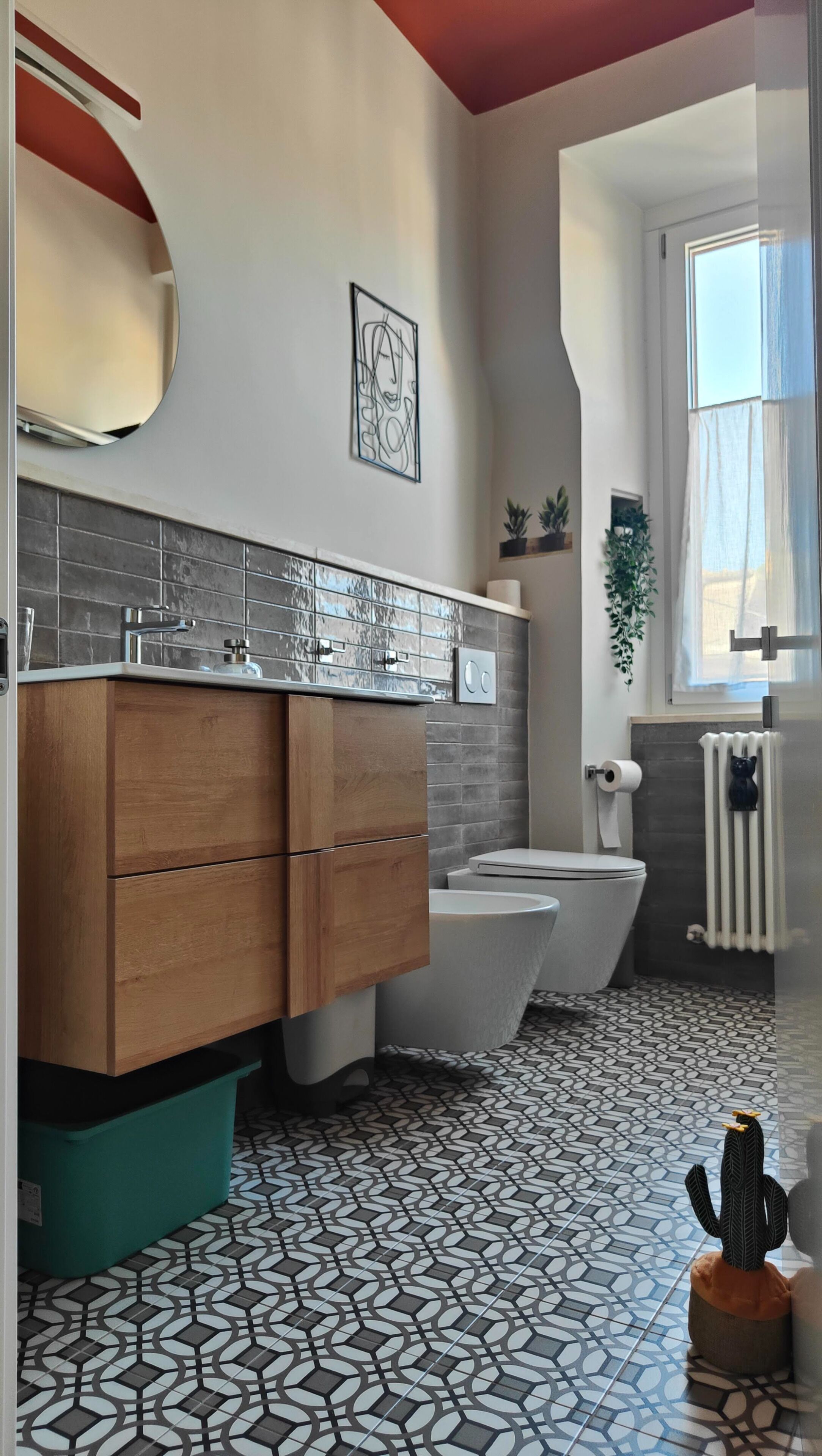 Ein modernes Badezimmer mit einem Holzlagerfläschchen, einer weißen Toilette, einer Badewanne und Fliesen mit Muster.