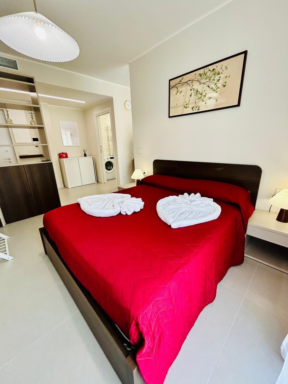 Ein Hotelzimmer mit einem großen Bett, einem Kleiderschrank, einem Schreibtisch und einem Badezimmer.