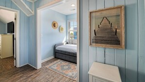 A bedroom with a bed, a dresser, a television, and a framed picture on the wall.