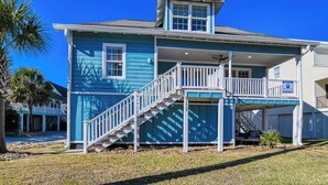 A two-story house with a balcony and a staircase leading to the second floor.
