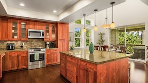 Una cucina moderna con mobili in legno, elettrodomestici in acciaio inossidabile e un'isola grande.