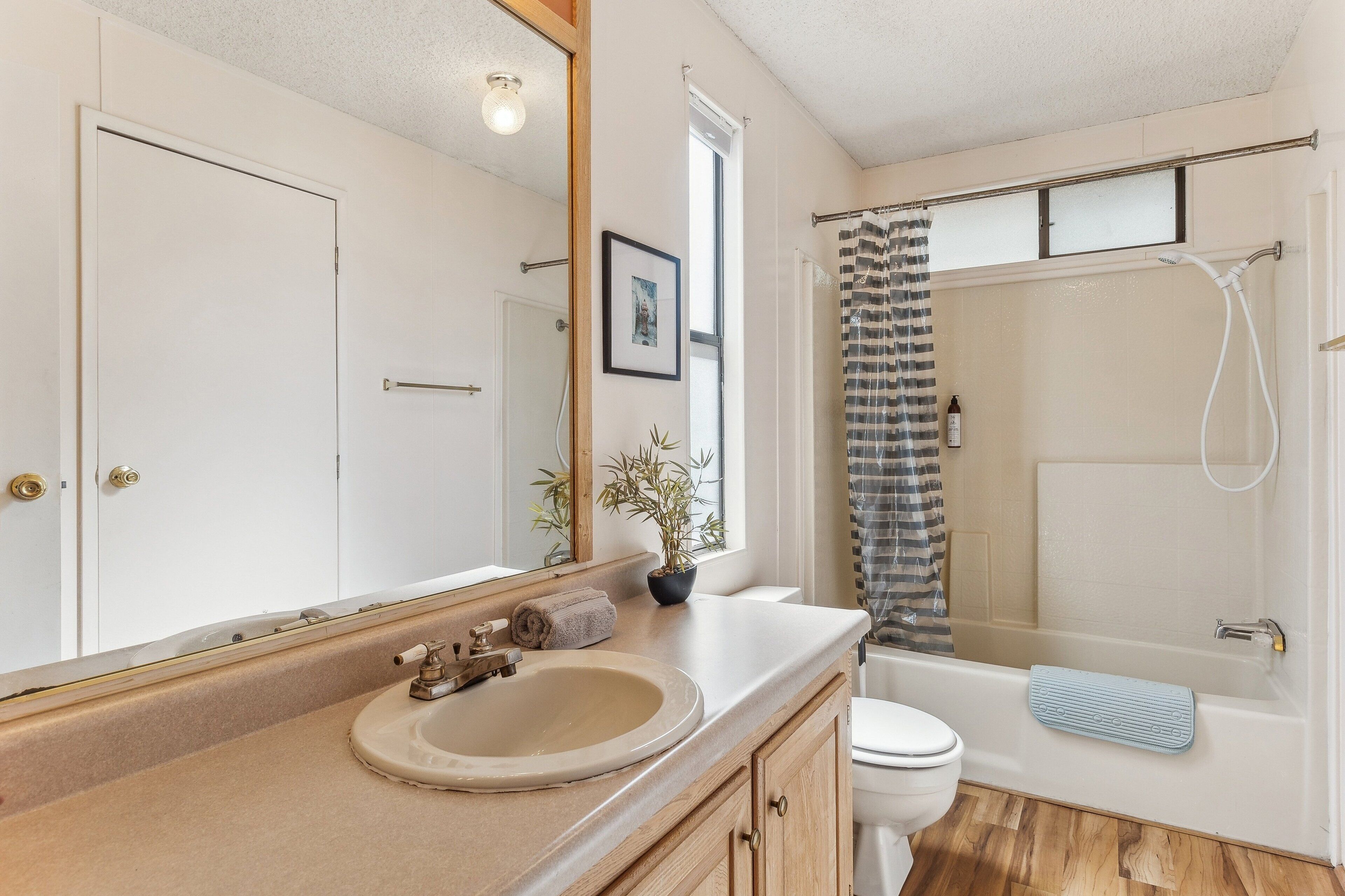 A bathroom with a sink, toilet, and shower.