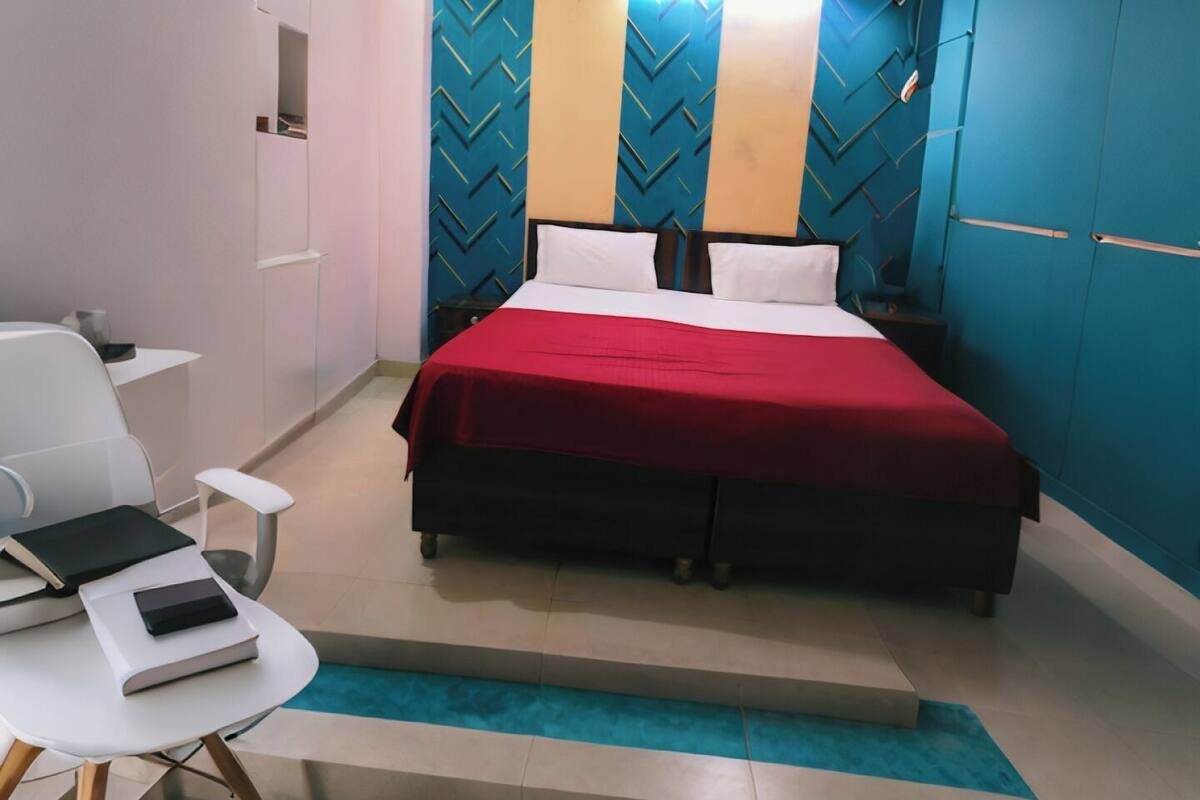 A modern bedroom with a bed, a desk, and a chair.