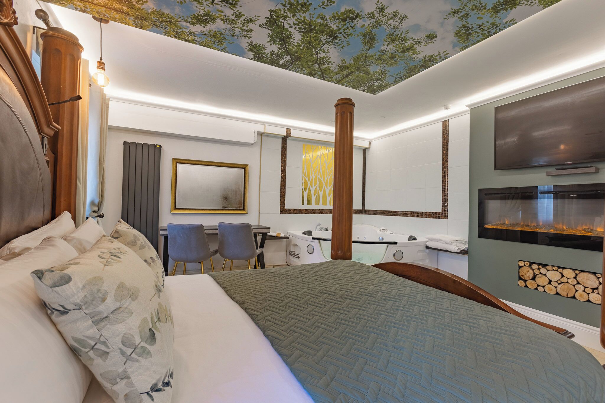 A hotel room with a bed, a desk, a chair, a bathtub, and a TV.