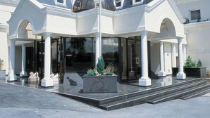 A hotel entrance with a covered waiting area, a central column, and a flagpole. - Durrant House Hotel  (Bideford)