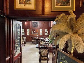 A room with wooden paneling, framed artwork on the walls, a large feather decoration, and a sign that reads 'Welcome.' - Durrant House Hotel  (Bideford)