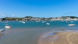 A coastal town with boats anchored in the water, a sandy beach, and houses in the background. - Durrant House Hotel  (Bideford)