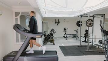 Et fitnesscenter med løbebånd, spinningcykler og styrketreningsudstyr.