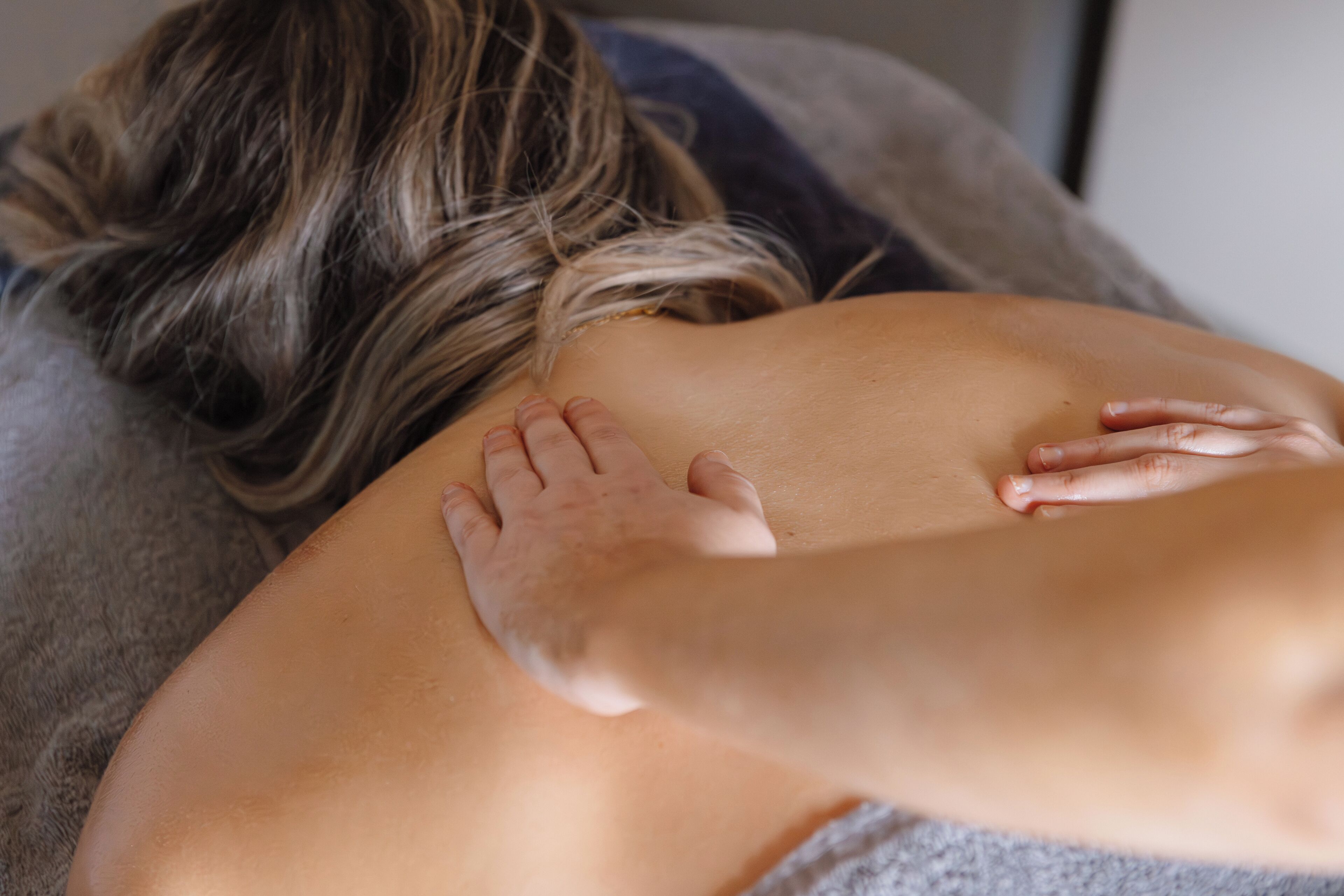 A person receiving a massage on a massage table.