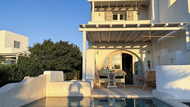 A pool area with a table and chairs, a covered seating area, and a clear view of the pool. - Argana Naxos private villa with pool and garden (Plaka)